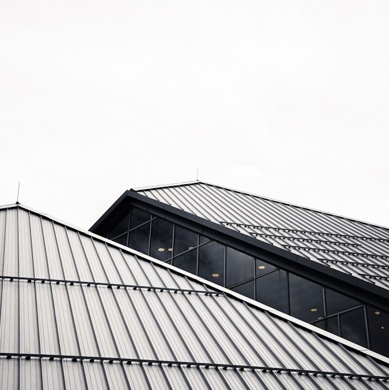 grayscale photo of building under cloudy sky